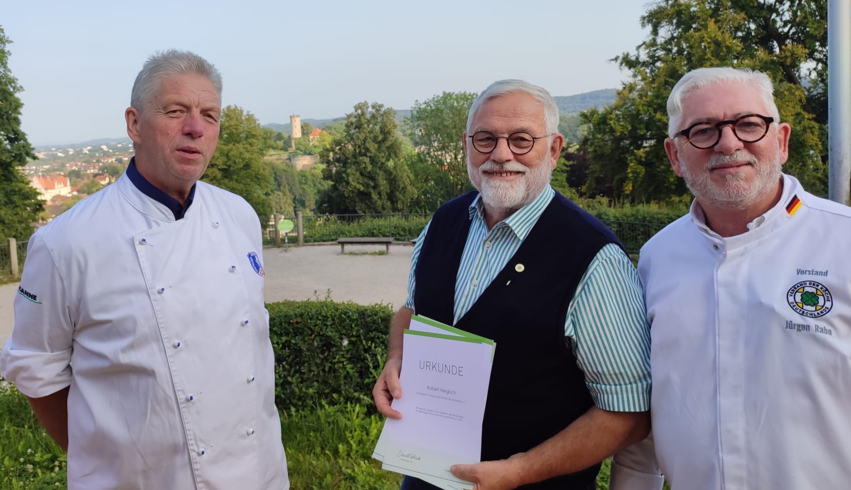 Stefan Grethe (links), Jubilar Robert Niegisch und Jürgen Rabe – im Hintergrund die Sparrenburg, das Wahrzeichen der Stadt Bielefeld. 